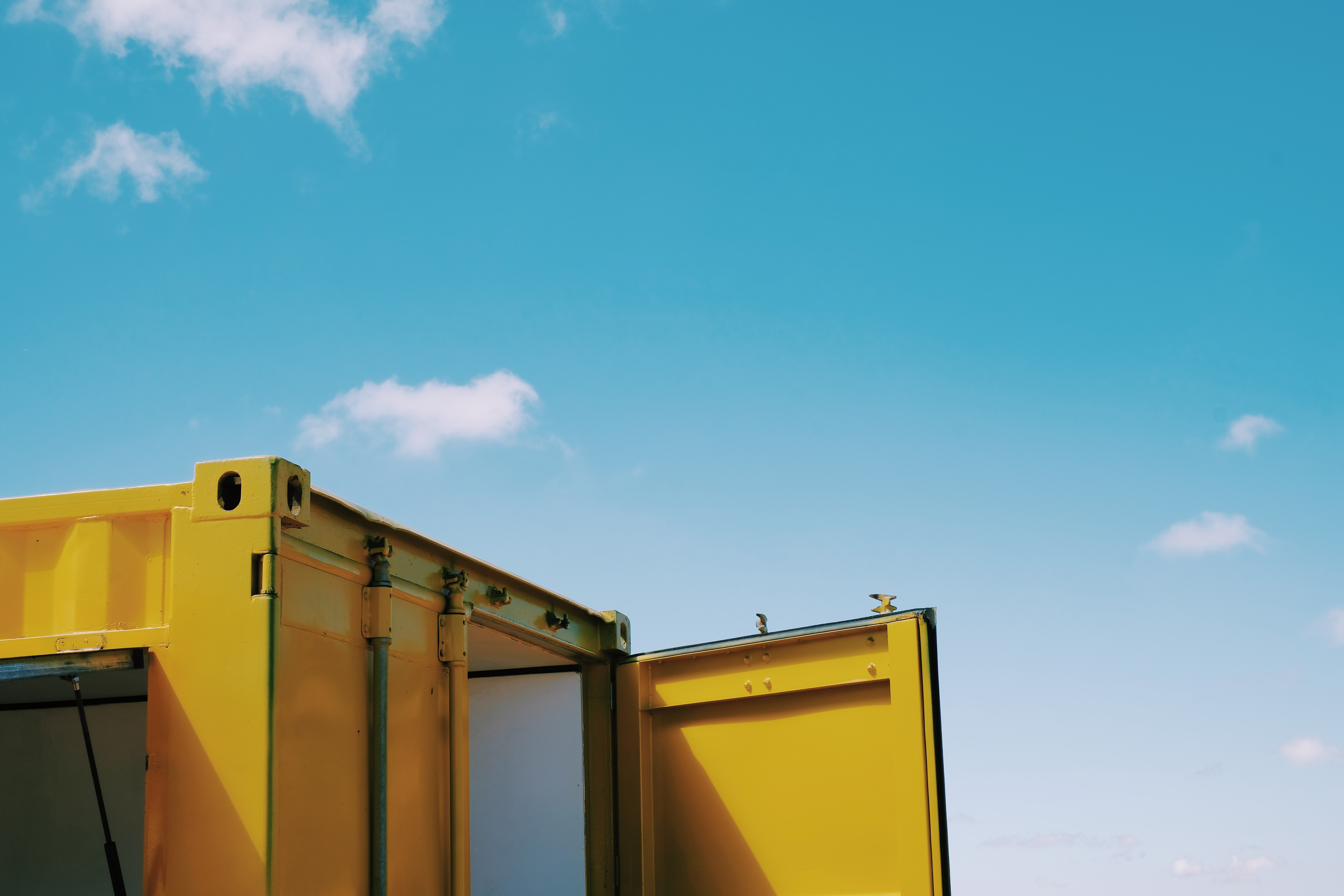 A single yellow shipping container up close,
with the door open,
but we can't see in
